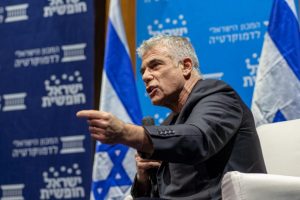 תמונה של יאיר לפיד מדבר בפאנל עם מקרופון