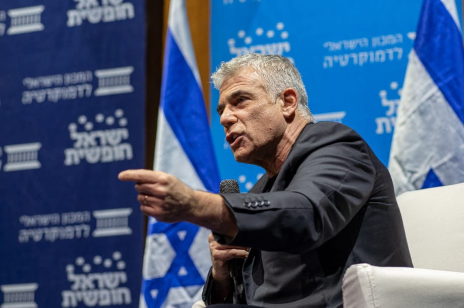 תמונה של יאיר לפיד מדבר בפאנל עם מקרופון
