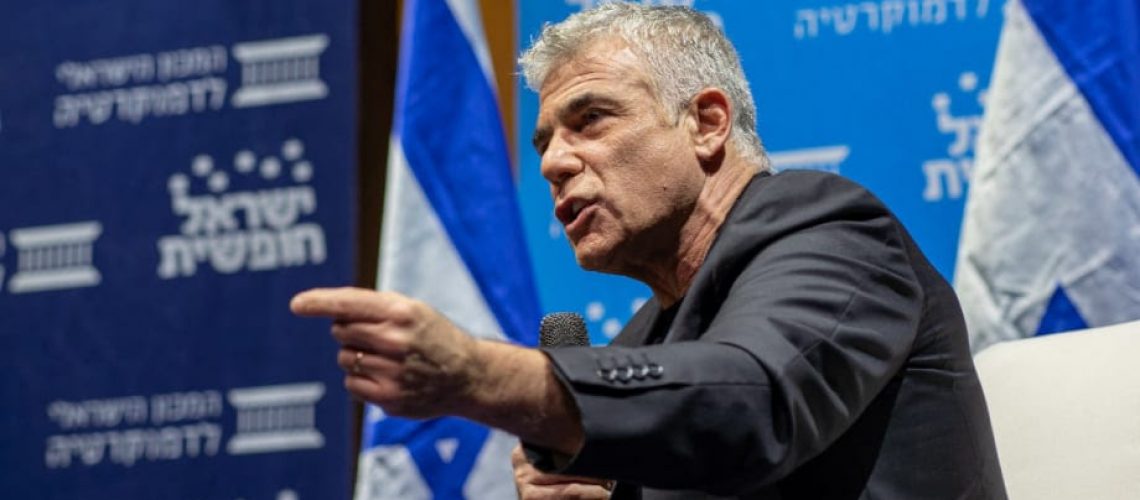 תמונה של יאיר לפיד מדבר בפאנל עם מקרופון